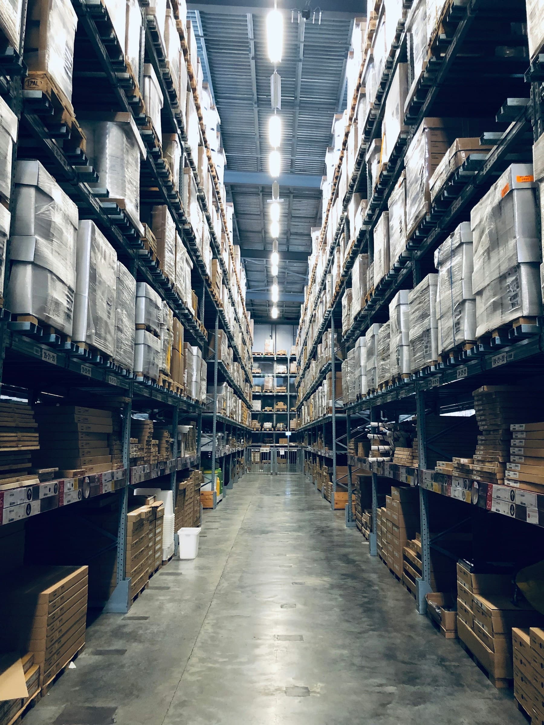 A warehouse aisle where organizational systems, people, and decisions meet